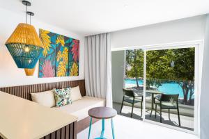 a living room with a couch and a table and chairs at Caribe Deluxe Princess - All Inclusive in Punta Cana