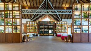 a large room with tables and chairs and windows at Tropical Deluxe Princess - All Inclusive in Punta Cana