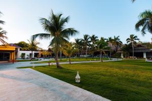 a park with palm trees and a walkway at Tropical Deluxe Princess - All Inclusive in Punta Cana