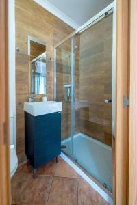 a bathroom with a shower and a sink and a tub at Abrigo de Milfontes - Suítes in Vila Nova de Milfontes