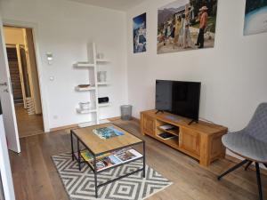 a living room with a television and a coffee table at Apartment Altmünster mit Traunsteinblick in Altmünster