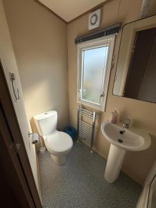 ein kleines Badezimmer mit Toilette und Waschbecken in der Unterkunft The Retreat 36 - Golden Palm Resort - Meadow Lakes Caravan Hire in Chapel Saint Leonards