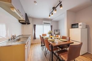 a kitchen and dining room with a table and a refrigerator at Likeliving in Nagoya
