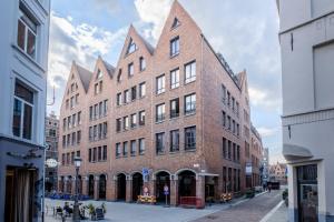 a large red brick building on a city street at Appartement historisch centrum Antwerpen in Antwerp