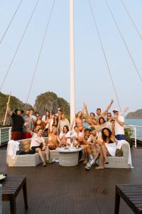 a group of people posing for a picture on a boat at The One Hostel & Rooftop Bar Catba in Cat Ba