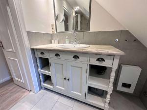 a bathroom with a sink and a mirror at Stilvolle 2 5 Zimmer Wohnung unter Reet in SPO mit Garten in Sankt Peter-Ording