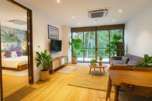 a living room with a couch and a tv at The Lush Apartments & Suites in Pilai Beach