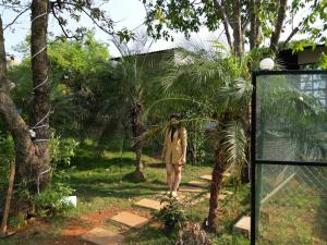 a woman standing on a path in a garden at Lake House in Malavli
