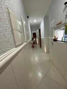 a kitchen with white walls and a white tile floor at Hotel jardim paulista in São Paulo