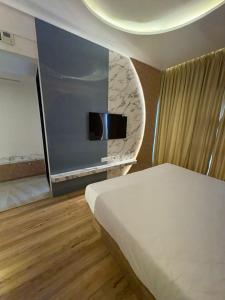 a bedroom with a bed and a flat screen tv at The Moon Hotel in Nerul