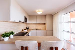 a kitchen with a wooden table and two chairs at Apartamento en Pasito Blanco PTOM11 in Pasito Blanco +5 photos