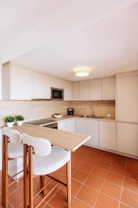 a kitchen with a wooden table and white cabinets at Apartamento en Pasito Blanco PTOM11 in Pasito Blanco