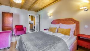 a bedroom with a large bed and a red chair at Przy Starej Piekarni Dream Apart in Szklarska Poręba