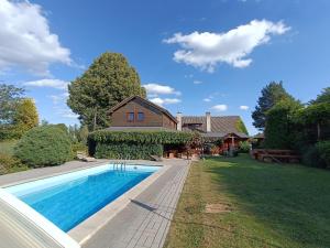 a swimming pool in front of a house at Penzion Pod Lípou in Dolní Brusnice