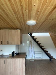 a kitchen with a wooden ceiling and a staircase at The Overlook in Bogë +13 photos