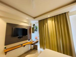 a room with a flat screen tv on a wall at Zoneout Stays Omaxe Hazratganj in Lucknow +7 photos