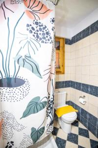 a bathroom with a shower curtain with a toilet at Strix Aluco Kalavryta in Kalavrita