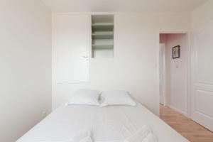 a white bedroom with a bed and a cabinet at Maison aux Moutiers - Wifi - Terrasse in Prigny