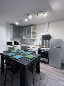 a kitchen with a black table and chairs in it at Le Cocon Familiale - Disneyland paris in Chessy