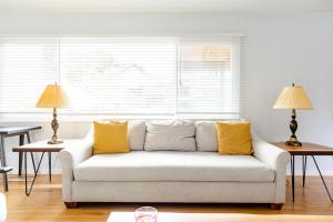 a white couch with yellow pillows in a living room at Malcolm Commons in Oakland +27 photos
