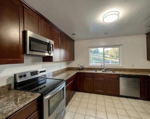 a kitchen with a stove and a microwave at Malcolm Commons in Oakland