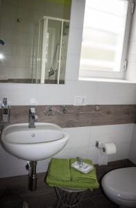 bagno con lavandino, servizi igienici e specchio di I MURETTI A SECCO B&B a Castel del Monte