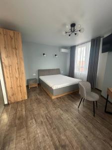 ein Schlafzimmer mit einem Bett und einem Stuhl und einem Fenster in der Unterkunft La familia ЖК республіка 195 in Kiew