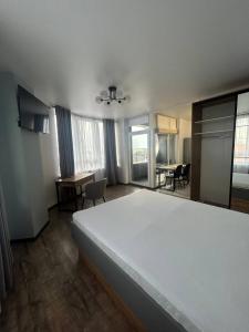 ein Schlafzimmer mit einem Bett und einem Tisch und Stühlen in der Unterkunft La familia ЖК республіка 195 in Kiew