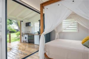 a bedroom with a bed with a canopy at Sanoa lodge - Bungalow Climatisé in Roussel +8 photos