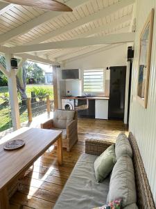 a living room with a couch and a table at Sanoa lodge - Bungalow Climatisé in Roussel