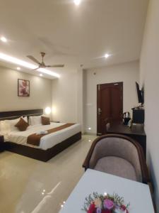 a hotel room with a bed and two chairs at Megha Residency in Ernakulam