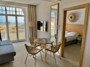 a hotel room with a table and chairs and a bed at Hotel Zhong Hua in Sopot