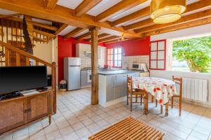 cocina con mesa y TV en una habitación en Résidence musicale de Panissal, en Montignac