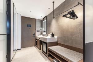 Atour Hotel Shanghai North Bund Dalian Road في شانغهاي: حمام مع حوض ومرآة