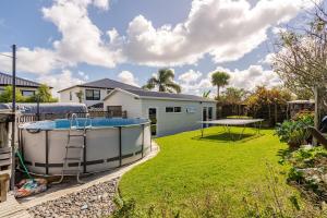 a backyard with a hot tub in the yard at Modern Garden Cottage with Private Outdoor Area - New Lynn in Auckland
