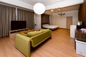 a living room with a couch and a television at Horizontel in Chiang Rai