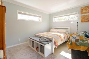 a small bedroom with a bed and a window at Modern Garden Cottage with Private Outdoor Area - New Lynn in Auckland