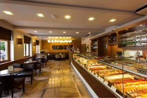 a restaurant with a display case filled with lots of pastries at Máté Holiday House in Gyula