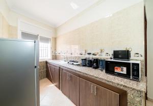 a kitchen with a counter top with a microwave at Cosy Apartment - Dar Tamraght in Tamraght Ouzdar