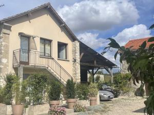 a house with a balcony and potted plants at La Fermette Champenoise in Jonquery