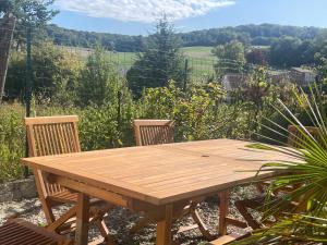 a wooden table and two chairs in a garden at La Fermette Champenoise in Jonquery +17 photos