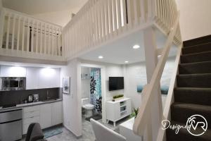 a living room with a staircase and a kitchen at Loft wqueen loft beach steps in Hollywood