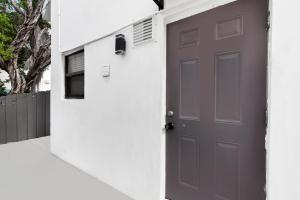 a gray door in a white wall with a house at Loft wqueen loft beach steps in Hollywood