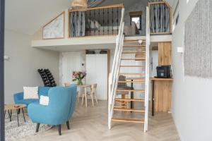 a living room with a loft bed and a blue chair at Studio Lakeview in Goes