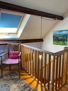 a room with a skylight and a chair on a staircase at Daffodil in Whitby