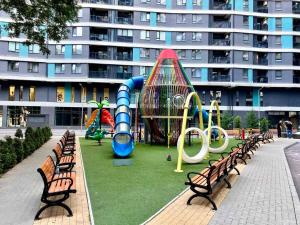 a park with benches and a playground in front of a building at Oasis Residence Luxury Apartament in Chişinău