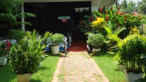 Un jardín con flores y plantas frente a un edificio. en Hotel Bridge View, en Batticaloa 6 fotos más