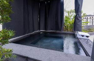 a swimming pool with a black shower curtain at Hotel Mvsa+Michelin 2 Starred Molino de Urdàniz in Taipei