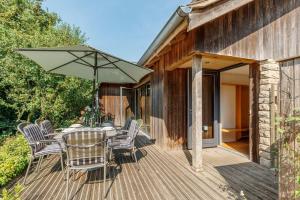 a wooden deck with a table and an umbrella at Underhill in Corfe Castle
