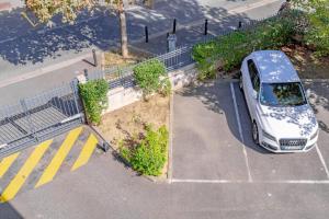 an overhead view of a white car parked in a parking lot at Séjour Cosy - 5 min Aéroport Orly - Parking Privée & Terrasse in Orly